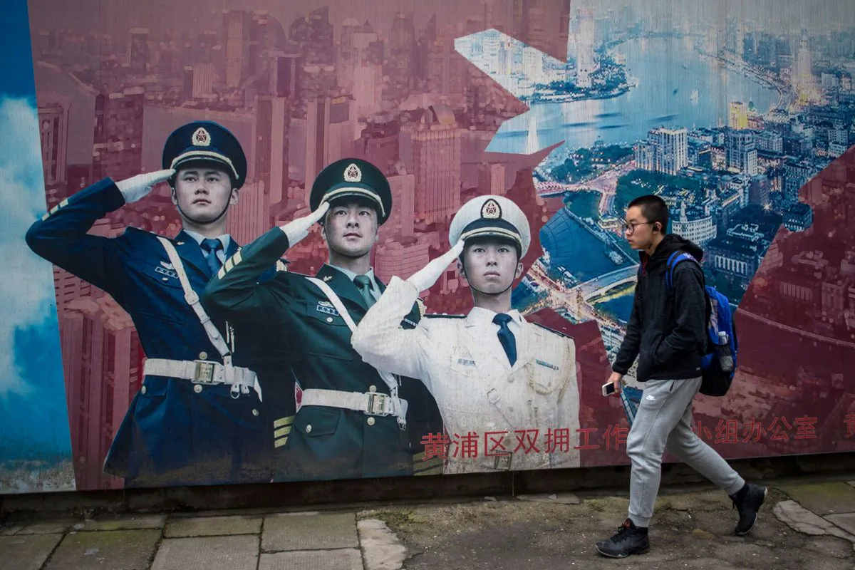 A man passes by a military propaganda poster in Shanghai on March 5, 2017. (JOHANNES EISELE/AFP/Getty Images)