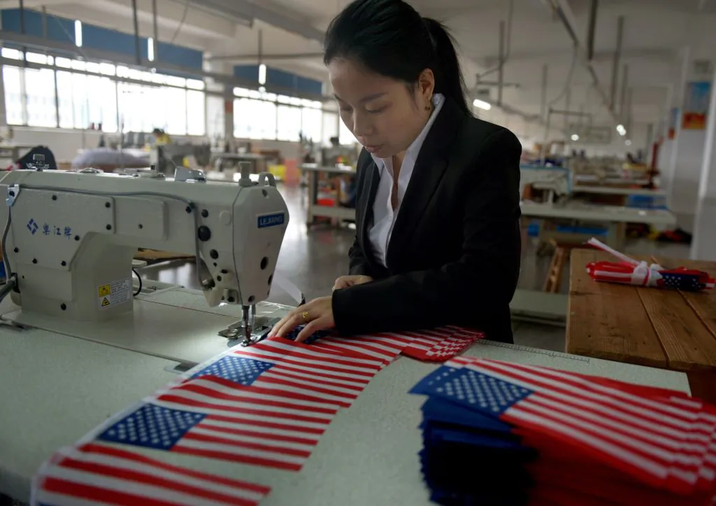 A Chinese employee makes US national flags at a factory in Wuyi, in China's eastern Zhejiang Province, on Nov. 6, 2017. (STR/AFP/Getty Images)