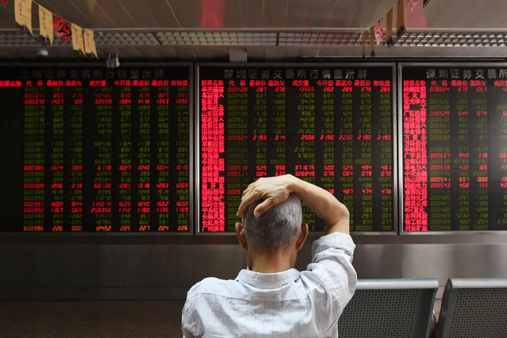 A man checks stock-price movements at a securities company in Beijing on July 4, 2018. (Greg Baker/AFP/Getty Images)
