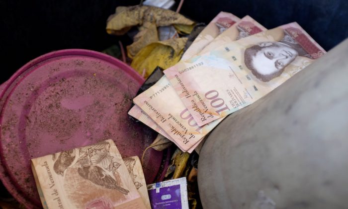 Venezuelan 100 bolivar notes thrown by people in a trash bin are seen at a gas station of the Venezuelan state-owned oil company PDVSA in Caracas, Venezuela, on Aug. 20, 2018. (Reuters/Marco Bello)