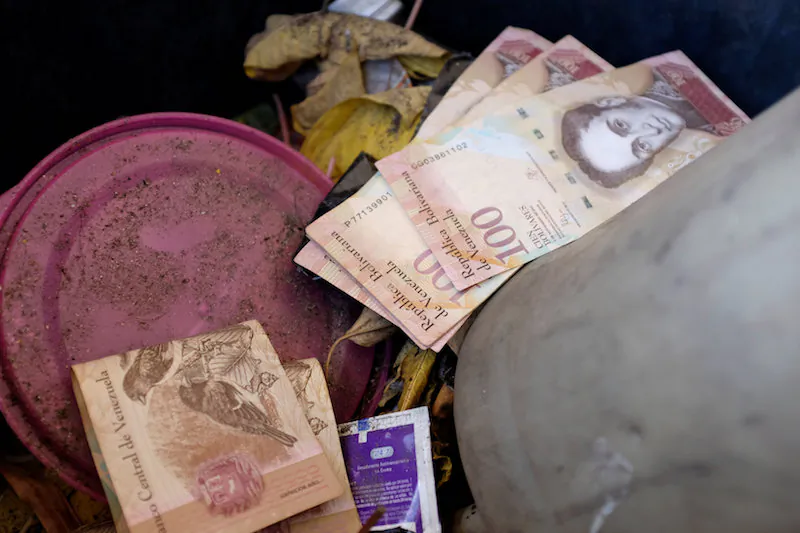 Venezuelan 100 bolivar notes thrown by people in a trash bin are seen at a gas station of the Venezuelan state-owned oil company PDVSA in Caracas, Venezuela, on Aug. 20, 2018. (Reuters/Marco Bello)