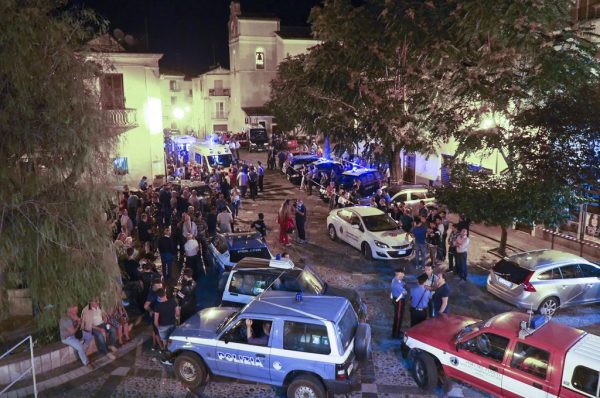 Rescuers and citizens wait in the central square of Civita, a village in the Italian Calabria southern region on Aug. 20, 2018.