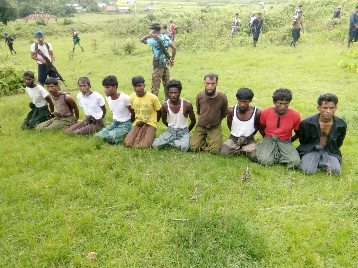 Ten Rohingya men with their hands bound kneel as members of Burmese security forces stand guard in Inn Din village, Burma, on Sept. 2, 2017. Later, pictures reportedly emerged of the same men’s bodies in a shallow grave. (File Photo/Reuters)