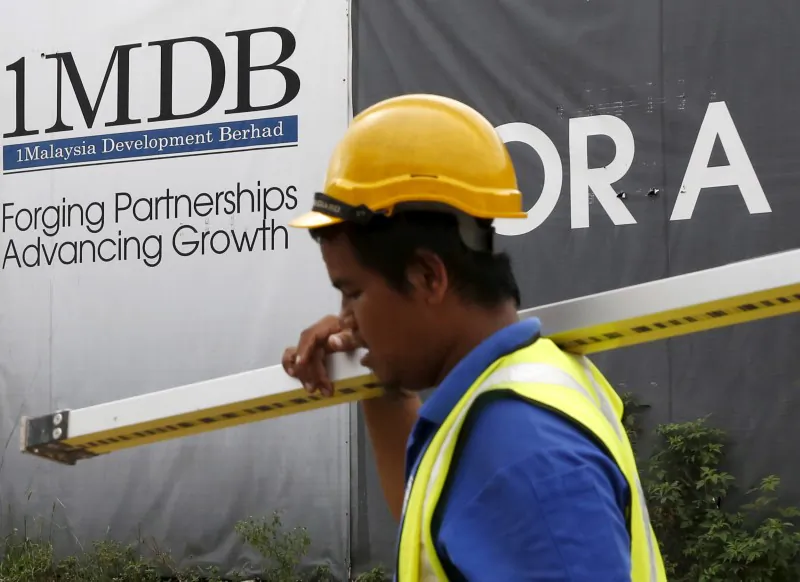 File Photo: A construction worker walks past a 1Malaysia Development Berhad (1MDB) billboard at the Tun Razak Exchange development in Kuala Lumpur, Malaysia February 3, 2016. (Reuters/Olivia Harris/File Photo)