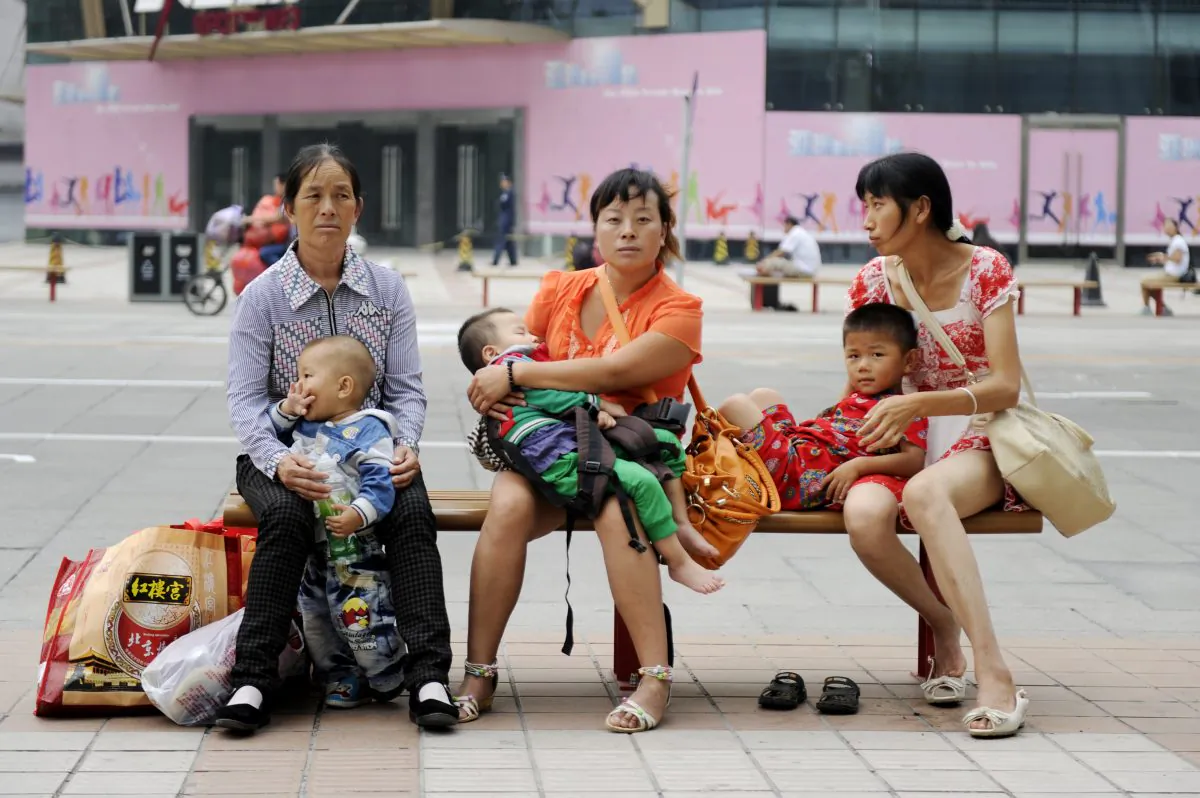 Women sit on a bench with their babies on a street in Beijing on September 6, 2012. (Wang Zhao/AFP/Getty Images)