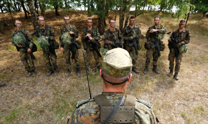 German Bundeswehr armed forces recruits receive a debriefing by an instructor during a drill at a military training area in Viereck, Germany, on Aug. 8, 2018. (Fabrizio Bensch/Reuters)