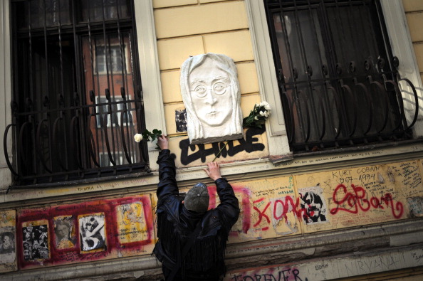 A man lays flowers at a John Lennon memorial