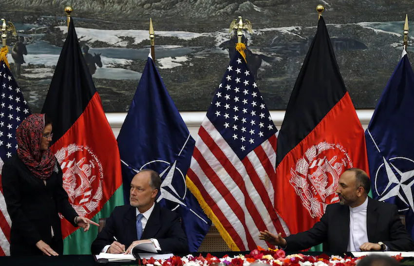 File Photo: Afghan national security advisor Hanif Atmar (R) and U.S. Ambassador James Cunningham sign the bilateral security agreement in Kabul September 30, 2014. (Reuters/Mohammad Ismail)
