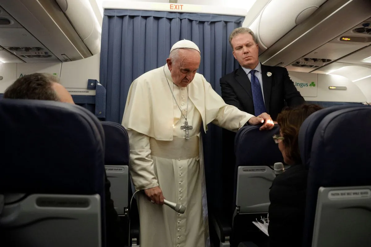 Pope Francis (C), flanked by Head of the Vatican press office, Greg Burke (R), addresses a reporter during a press conference in flight while returning from Ireland to The Vatican at the end of his two-day visit to Ireland on Aug. 26, 2018. (GREGORIO BORGIA/AFP/Getty Images)