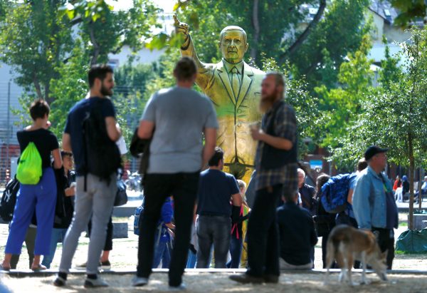 People in front of a golden statue of the Turkish president