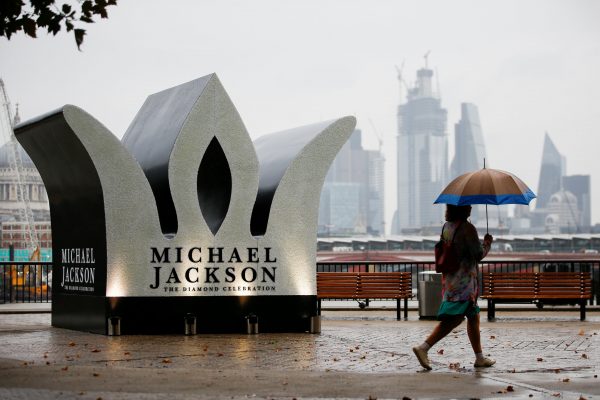 A woman walks past a temporary monument for Michael Jackson erected in London