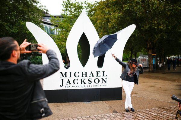 A fan poses at a monument of Michael Jackson in London