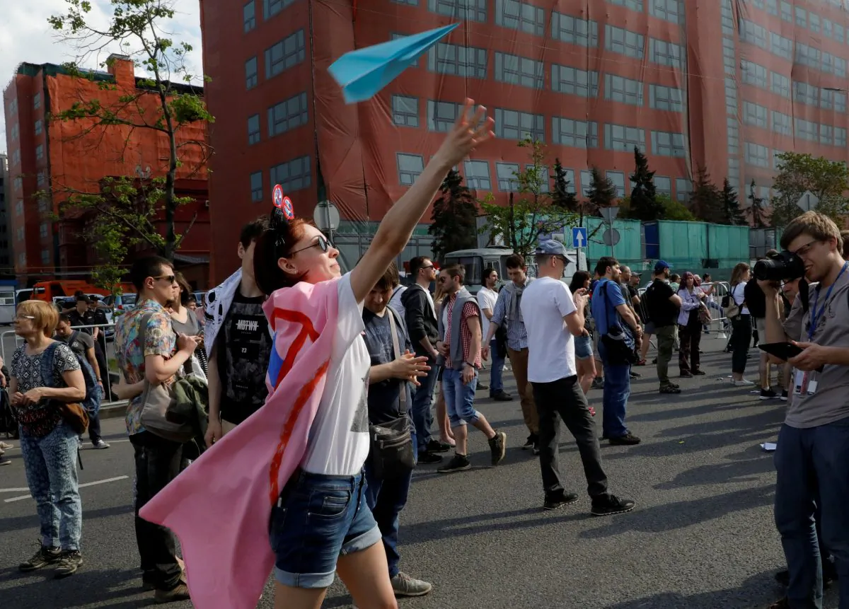 A youth releases a paper plane, symbol of Telegram messenger, during a rally in protest against a court decision to block it because it violated Russian regulations, in Moscow on May 13, 2018. (Reuters/Tatyana Makeyeva/File Photo)