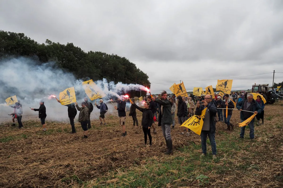 Members of French farmers union La Confederation Paysanne walk with flares as they occupy fields belonging to Chinese farmers, during a demonstration against 'land grabbing' by Chinese investors, in Murs, France. on Aug. 29, 2018. (Guillame Souvant/AFP/Getty Images)