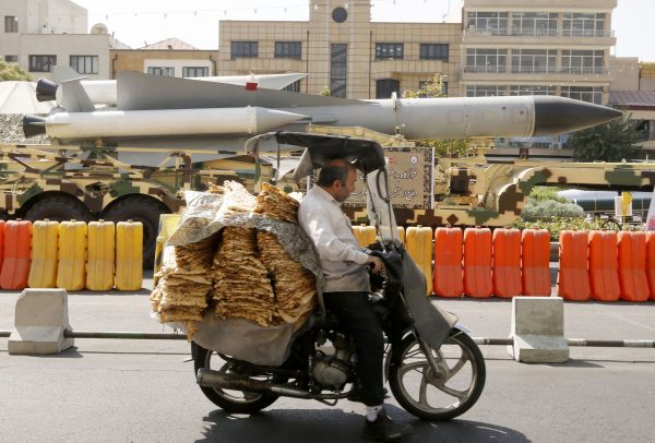 A man rides past missiles in Iran