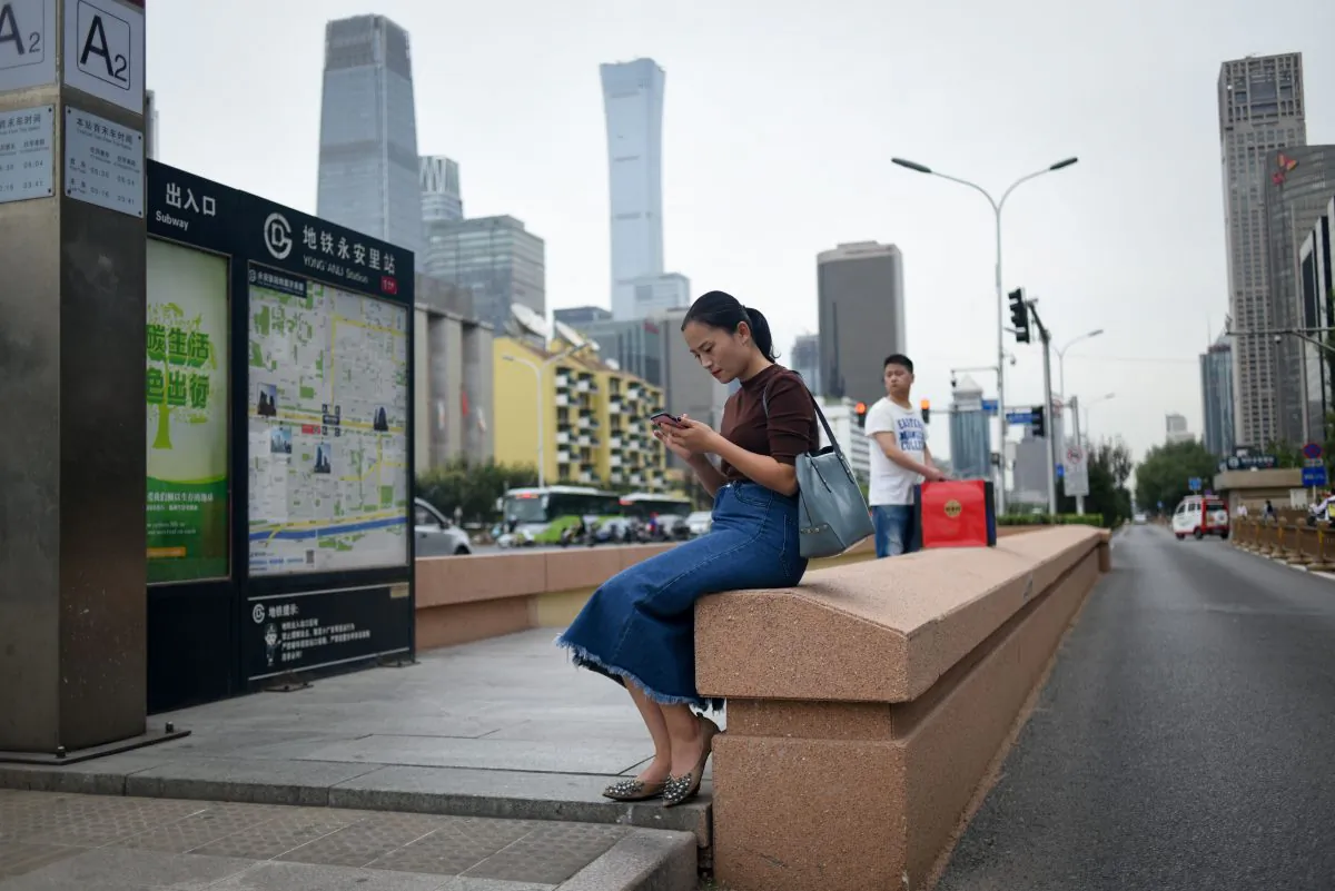 A woman uses her mobile phone at the entrance of an underpass in Beijing on Sept. 18, 2018. (Wang Zhao/AFP/Getty Images)