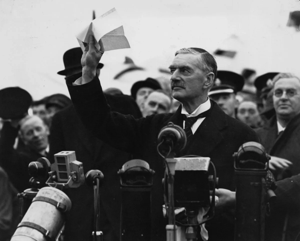 British statesman and prime minister Neville Chamberlain (1869 - 1940) at Heston Airport on his return from Munich after meeting with Hitler, making his 'peace in our time' address. (Central Press/Getty Images)