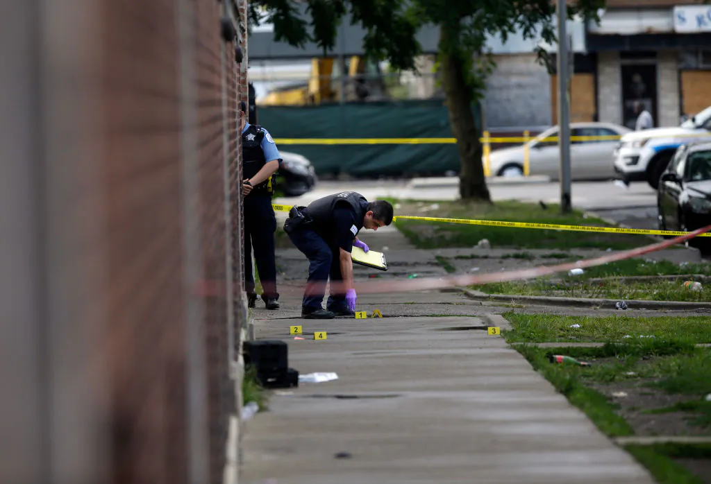 Chicago Police officers and detectives investigate a shooting where multiple people were shot in Chicago on Aug. 5, 2018. (Photo by Joshua Lott/Getty Images)
