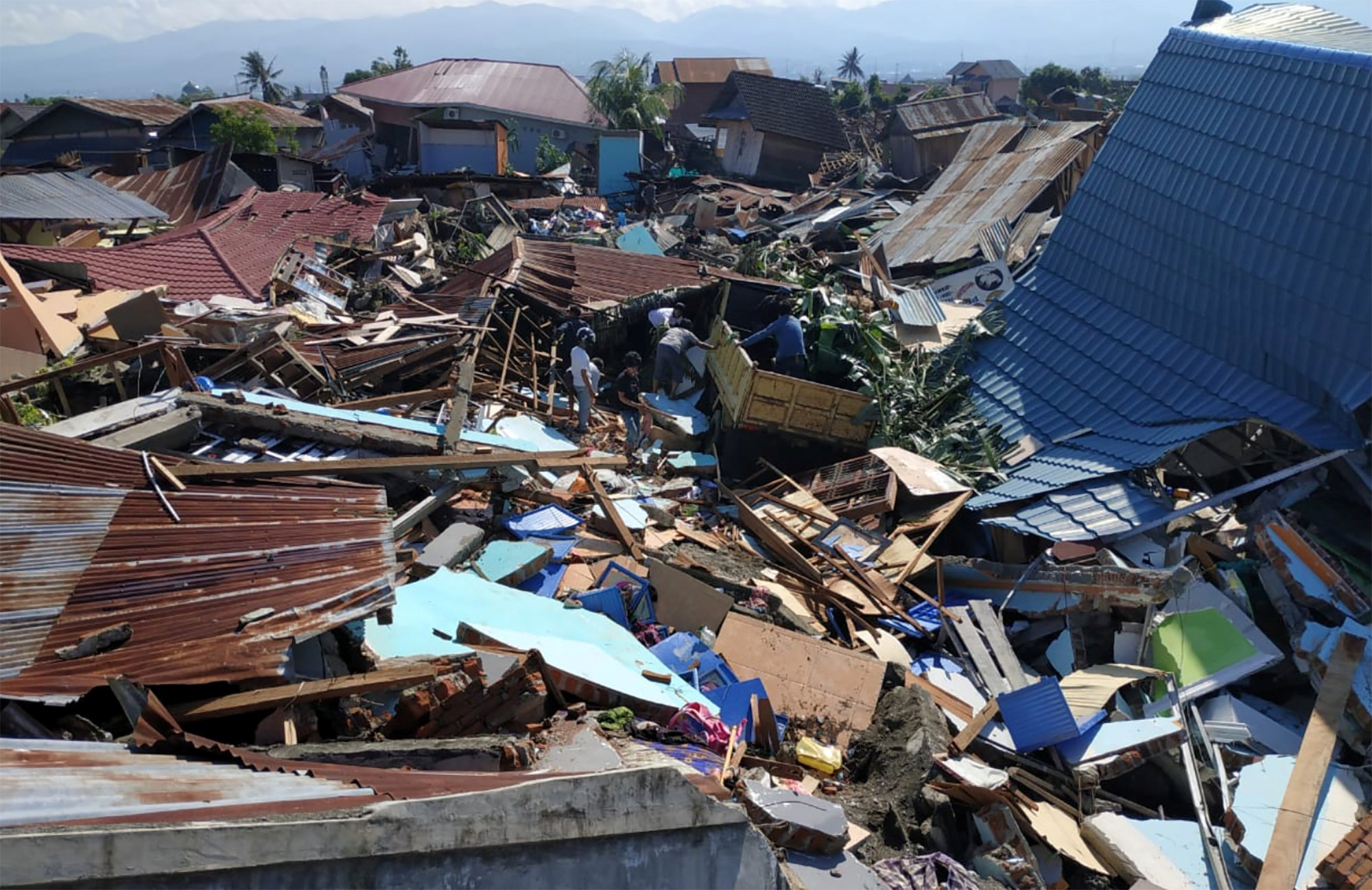 People search debris following earthquake and tsunami in Palu