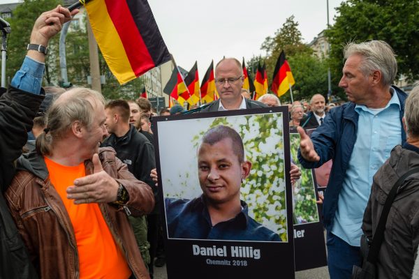People carry a portrait of the victim of a stabbing