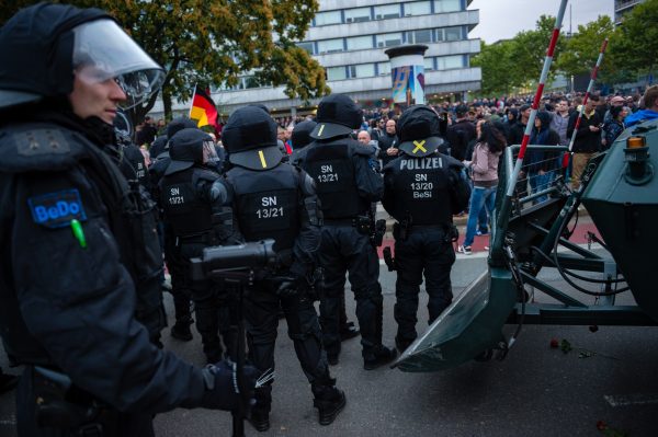 Riot police observe participants in a right-wing march