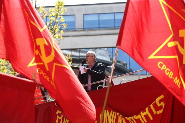 Corbyn surrounded by communist flags