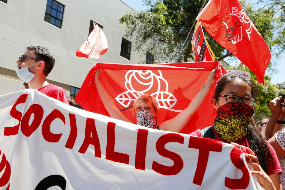 Democratic Socialists of America counter protesters holding signs and flags as they march, protesting a rally on Aug. 5, 2018 in downtown Berkeley, California. (Amy Osborne/AFP/Getty Images)