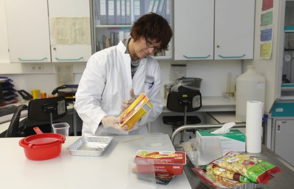 A laboratory technician checks for possible horsemeat in a lasagne