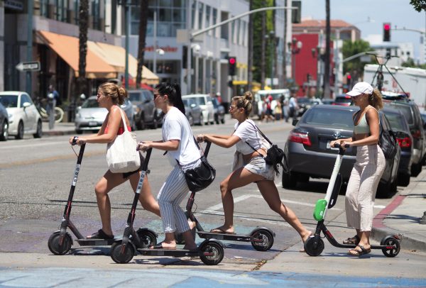 Women ride scooters in Santa Monica in California