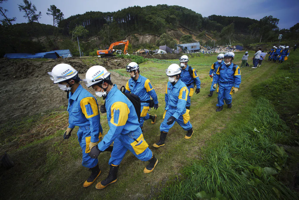 Police walk as they search for missing persons at the site of a landslide after an earthquake in Atsuma town, Hokkaido, northern Japan, Sept. 7, 2018.  (AP/Eugene Hoshiko)