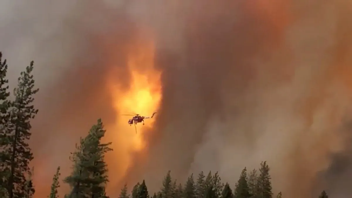 A helicopter drops water on a forest fire in Shasta County in California, on September 5, 2018. (California Highway Patrol/via Reuters)