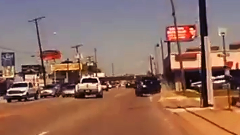 Speeding car mounts the sidewalk to flee police.