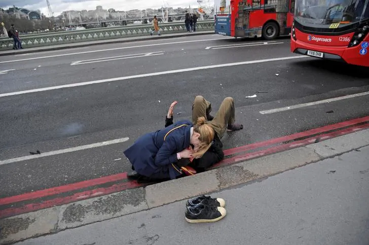 A woman assists an injured person after the attack on Westminster Bridge in London, on March 22, 2017. (Reuters/Toby Melville/File photo)