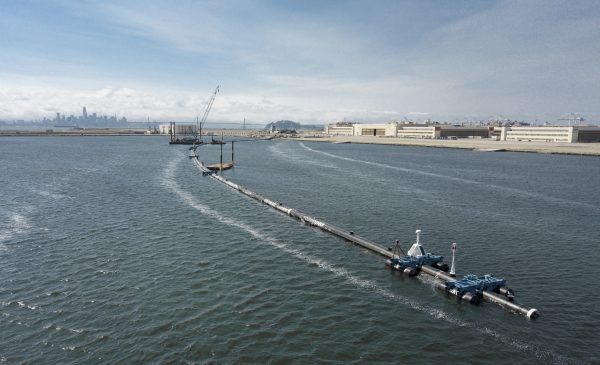 A long floating boom that will be used to corral plastic litter in the Pacific Ocean is assembled