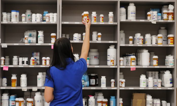 A pharmacy technician grabs a bottle of drugs off a shelve at the central pharmacy of Intermountain Heathcare in Midvale, Utah, on Sept. 10, 2018. (George Frey/Getty Images)