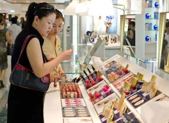 A woman checks out lipsticks at a department store in Shanghai on Aug. 16, 2004. (Liu Jin/AFP/Getty Images)