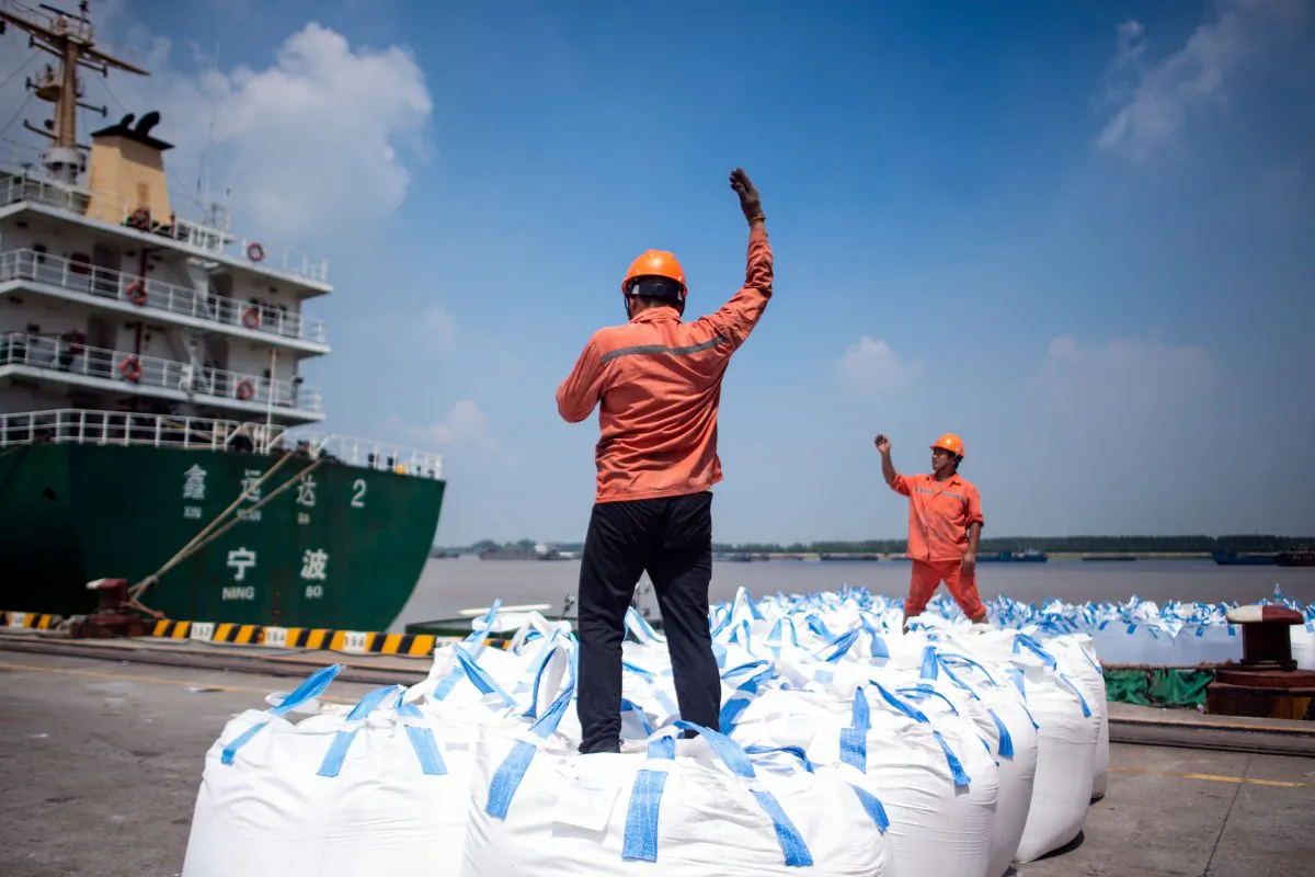 Workers unload bags of chemicals at a port in Zhangjiagang in eastern China's Jiangsu Province on Aug. 7, 2018. (JOHANNES EISELE/AFP/Getty Images)