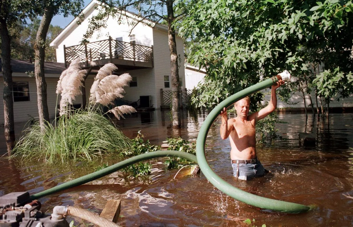 File photo showing a North Carolina resident trying to pump flood waters from around his home following heavy rains from Hurricane Floyd on 17 Sept. 1999 in Ocean Isle Beach, NC. Floyd killed over a dozen people, wreaked serious damage and triggered the largest peacetime evacuation ever undertaken in the United States. (Steve Schaefer/AFP/Getty Images)