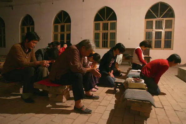 Christians pray during a mass at a village church in the outskirts of Yanshi City, Henan Province, on Oct. 6, 2006. (China Photos/Getty Images)