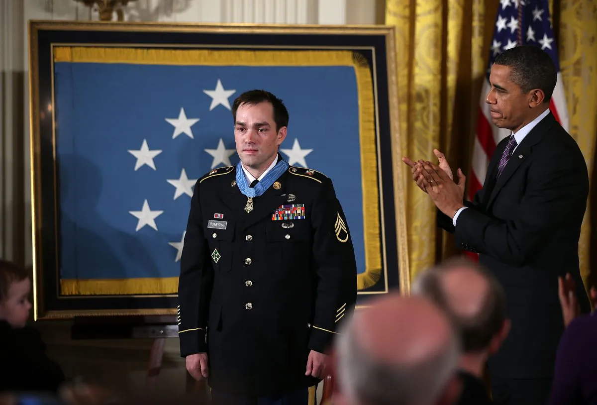 President Barack Obama (R) applauds after presenting the Medal of Honor for conspicuous gallantry to Clinton Romesha (L), a former Army Staff Sergeant, at the White House in Washington on Feb. 11, 2013. (Alex Wong/Getty Images)