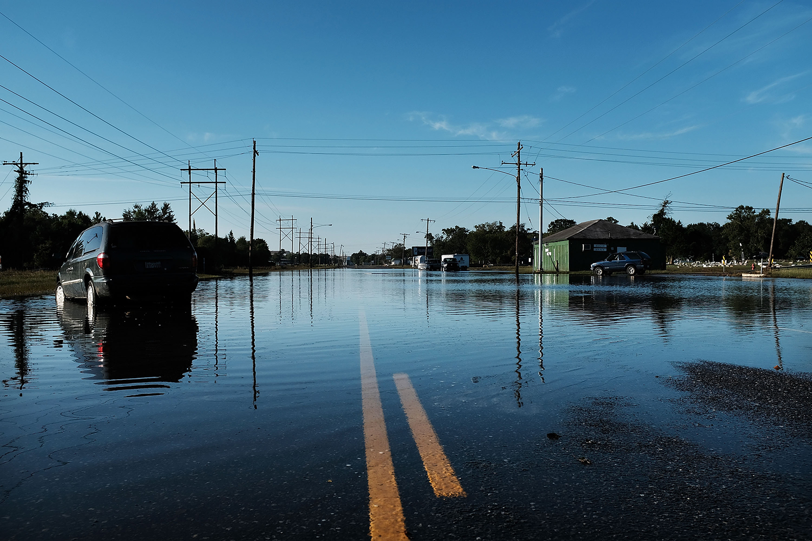 An abandoned car sits in high water along a street in in Orange, Texas