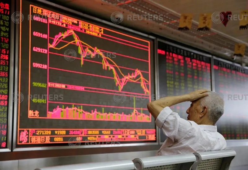 An investor looks at a board showing stock information at a brokerage office in Beijing on July 6, 2018. (Jason Lee/Reuters)