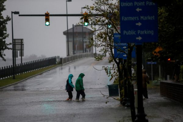 People walk along a flooded local street