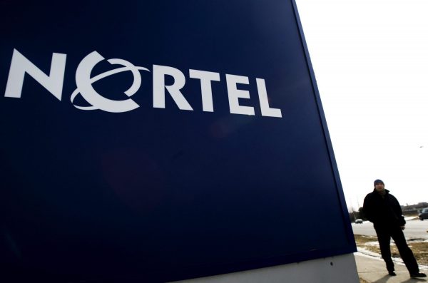 A man walks past a company sign at a NortelNetwroks office tower in Toronto on Feb. 25, 2009. (The Canadian Press/Nathan Denette)