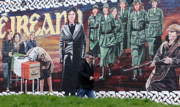 A man walks past a Republican mural