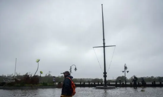 Weatherman Dramatically Braces for Hurricane Florence While Two People Stroll By