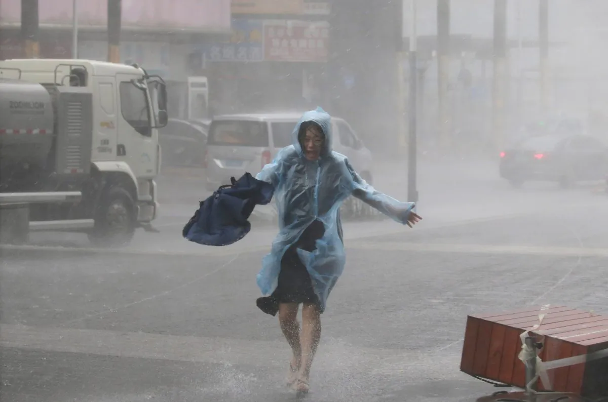 A woman runs in the rainstorm as Typhoon Mangkhut approaches, in Shenzhen City, Guangdong Province, China, on Sept. 16, 2018. (Reuters/Jason Lee)