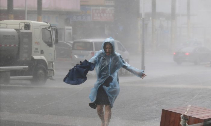 A woman runs in the rainstorm as Typhoon Mangkhut approaches, in Shenzhen City, Guangdong Province, China, on Sept. 16, 2018. (Reuters/Jason Lee)