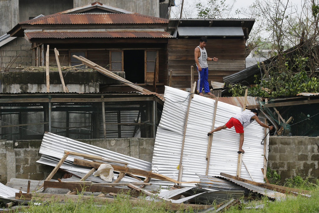 Residents work to repair a damaged roof in Philippines
