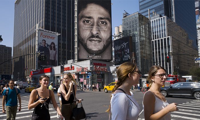 People walk by a Nike advertisement featuring Nike ambassador Colin Kaepernick, a former NFL football star, in New York City on Sept. 6, 2018. (Mark Lennihan/AP Photo)